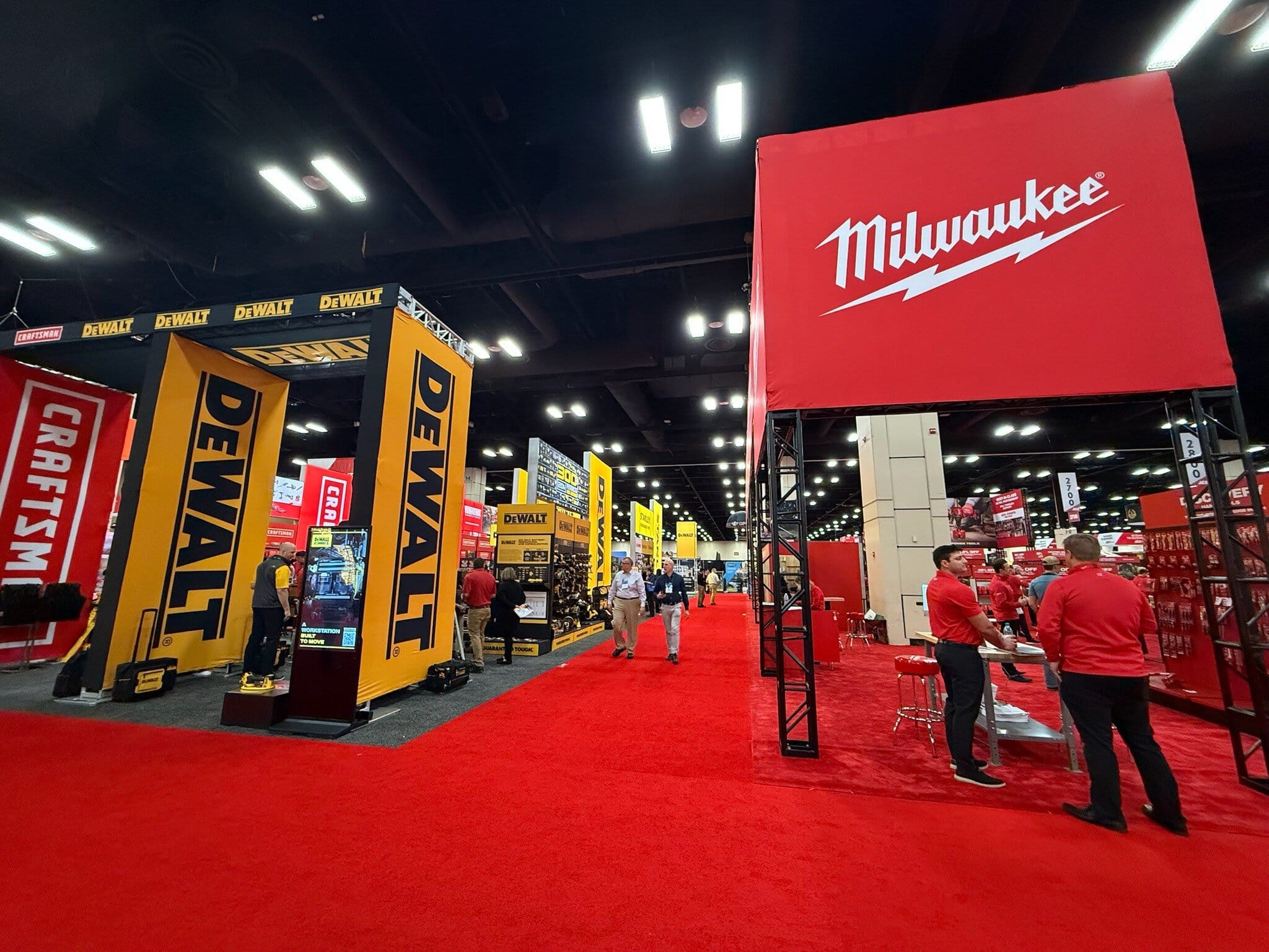 Tool brand displays at trade show with red carpets.