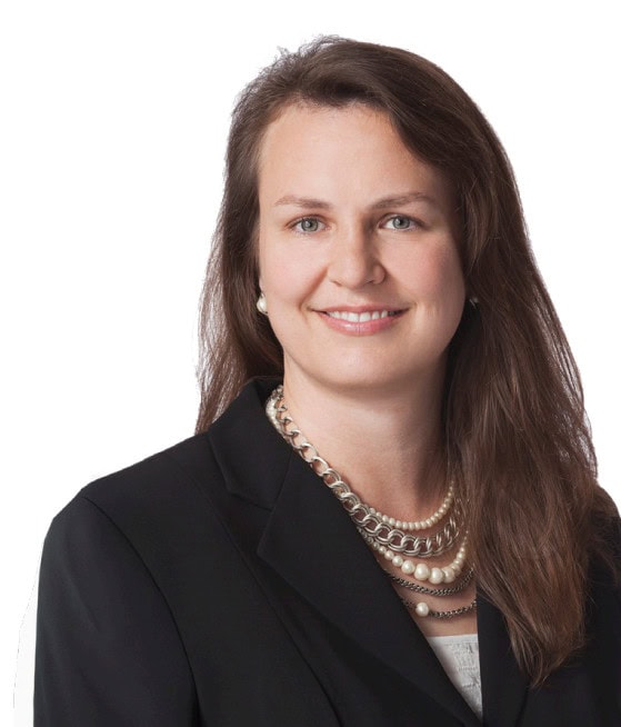 Woman in business attire smiling with necklace