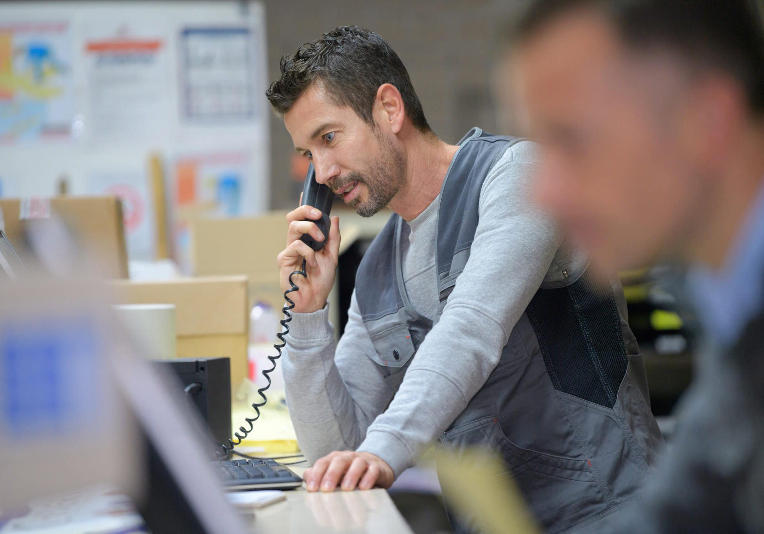 Man talking on phone at work desk