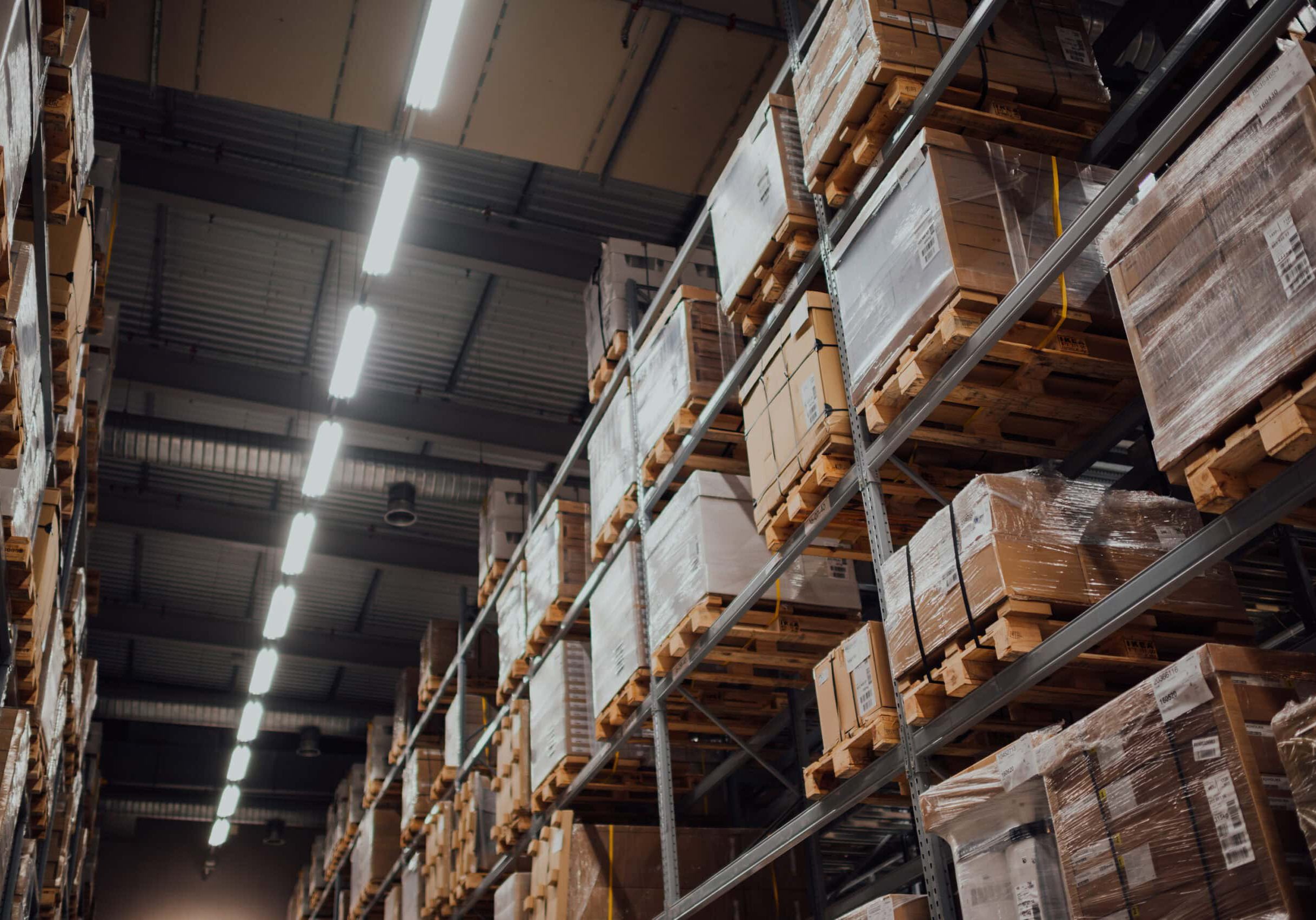 Warehouse shelves with stacked pallets of boxes.
